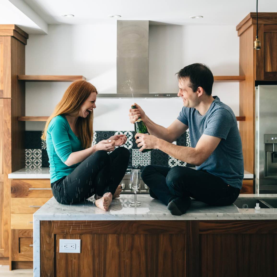 couple sitting in kitchen with champagne